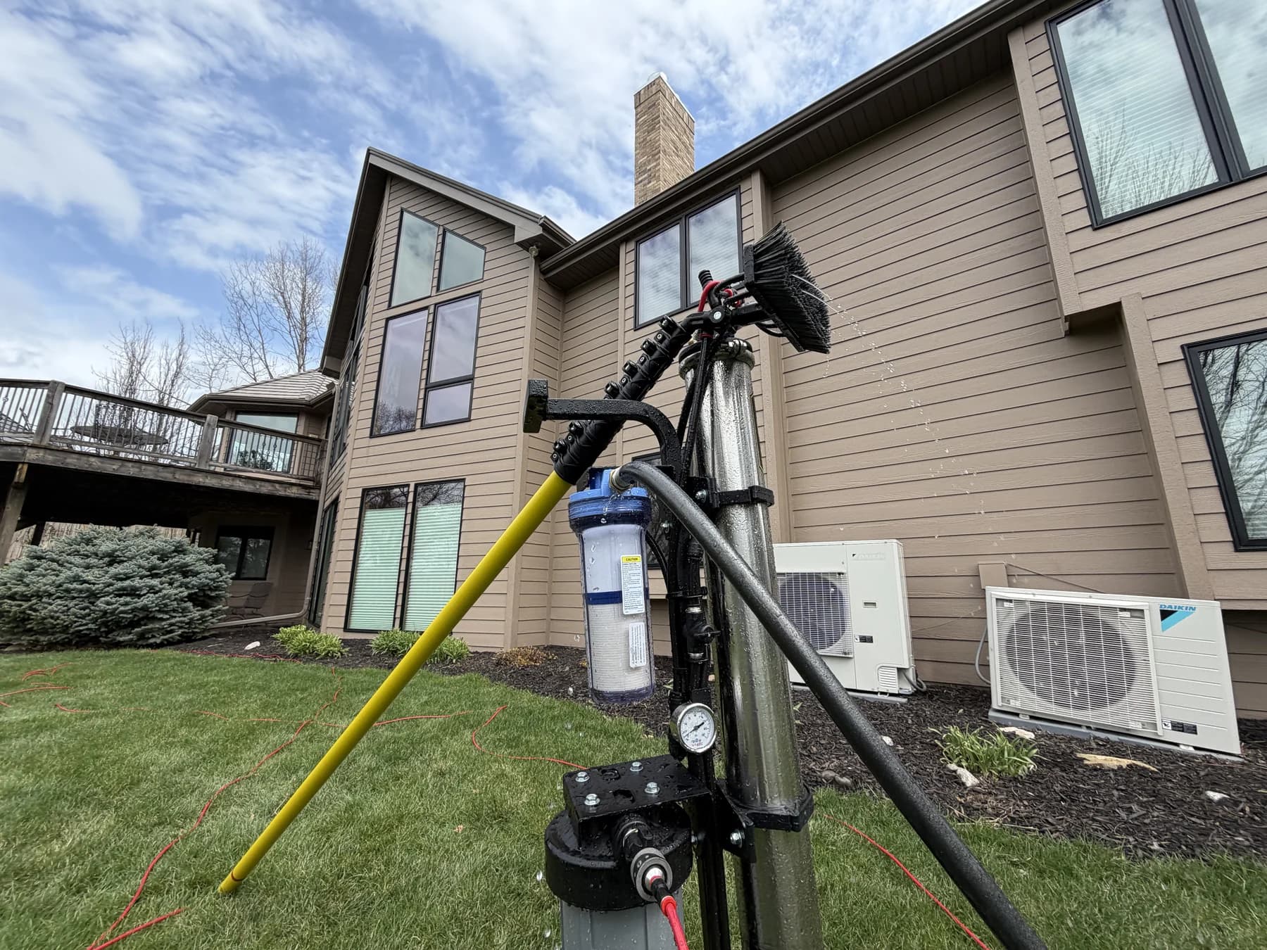 Water-fed pole equipment beside a two-storey Omaha home